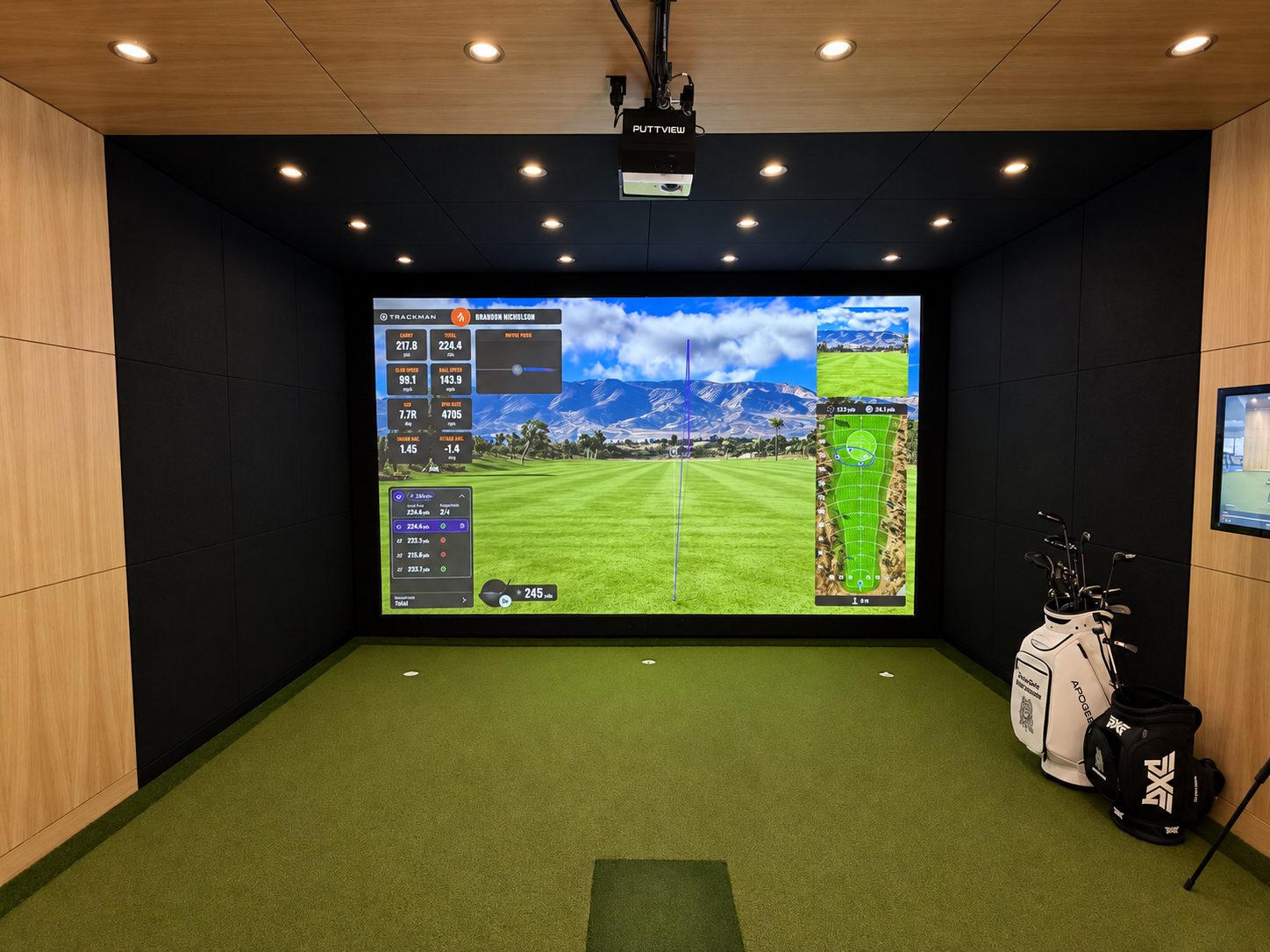 Front view of the TrackMan practice screen above the hitting strip and putting cups
