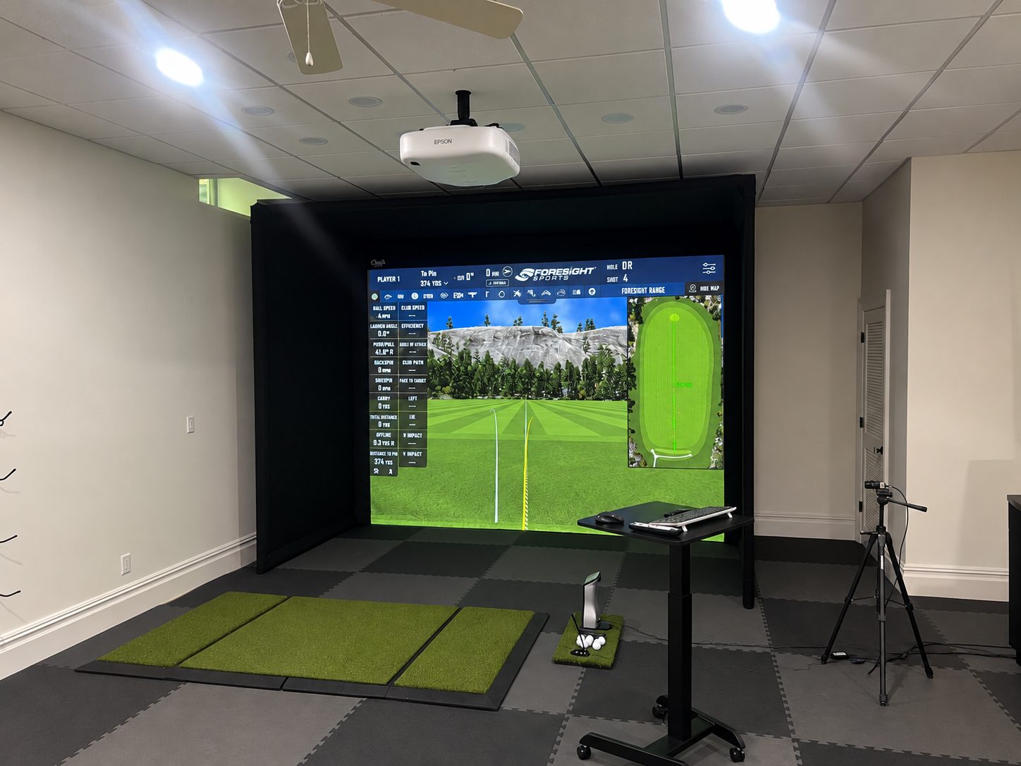 Wide view of a Foresight simulator room with ceiling projector and hitting area